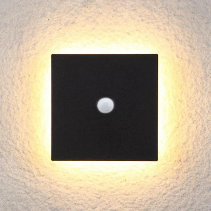 Square black modern LED wall lamp with motion sensor mounted on an exterior textured wall