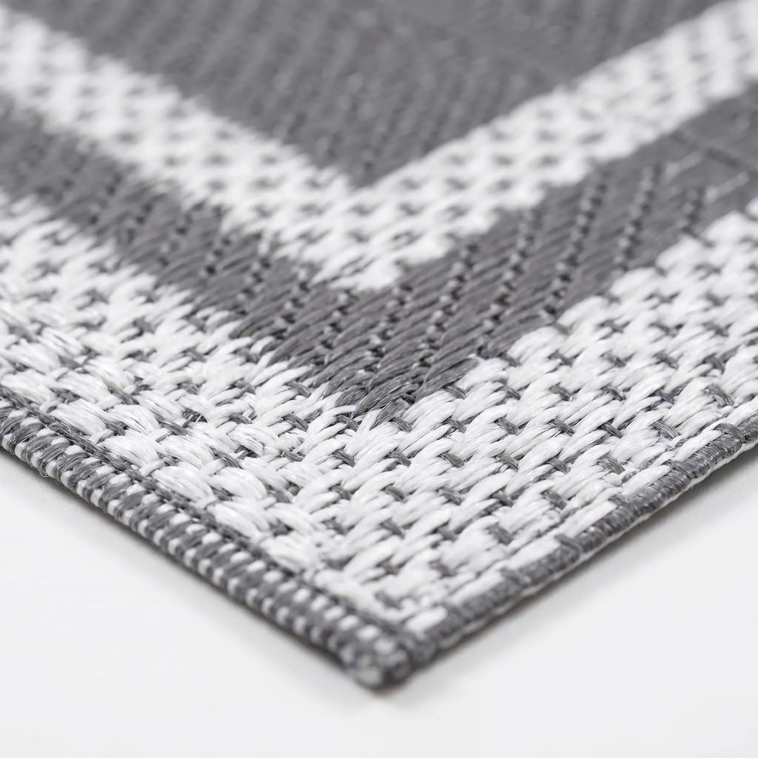 Close-up shot of the woven gray and white polypropylene pattern on the outdoor mat