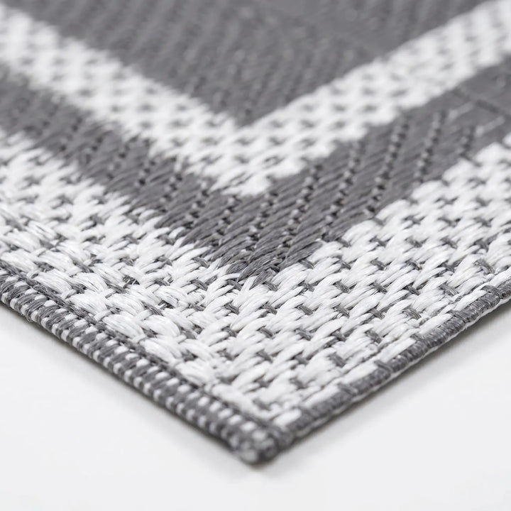 Close-up shot of the woven gray and white polypropylene pattern on the outdoor mat
