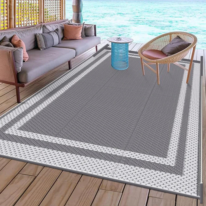 Water-resistant camping rug laid out on wooden decking