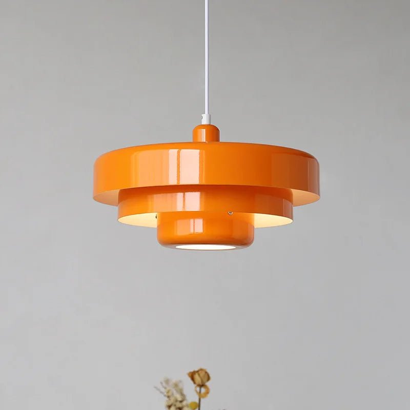 Modern orange Scandinavian pendant light hanging against a neutral background