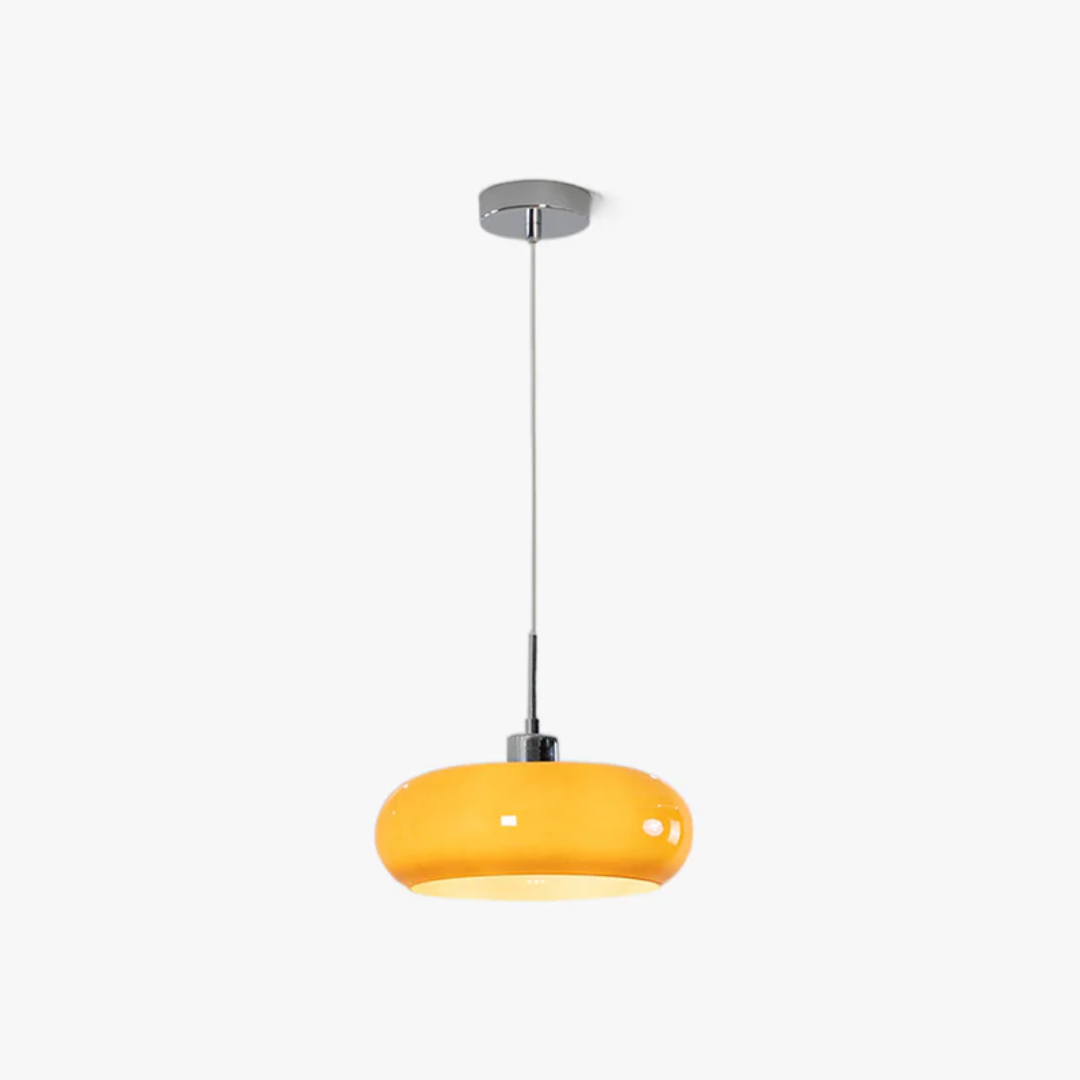Modern round LED pendant light hanging over a minimalist dining table