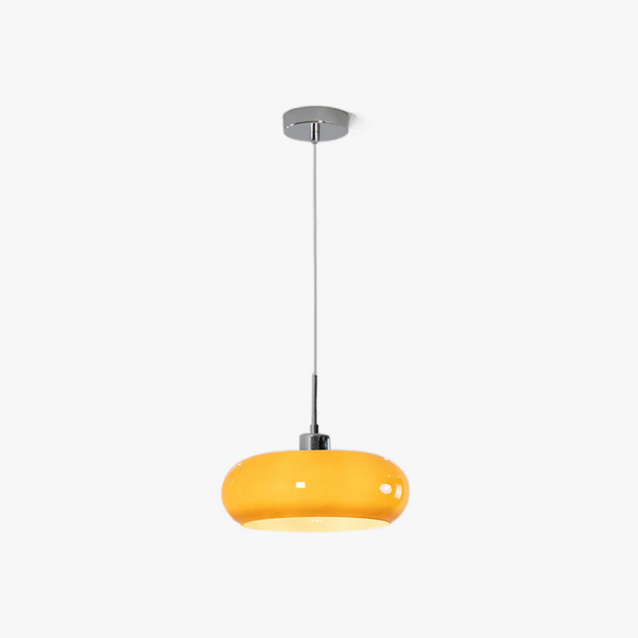 Modern round LED pendant light hanging over a minimalist dining table