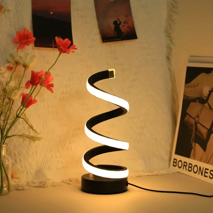 Modern S-shaped LED desk lamp in black on a contemporary office desk