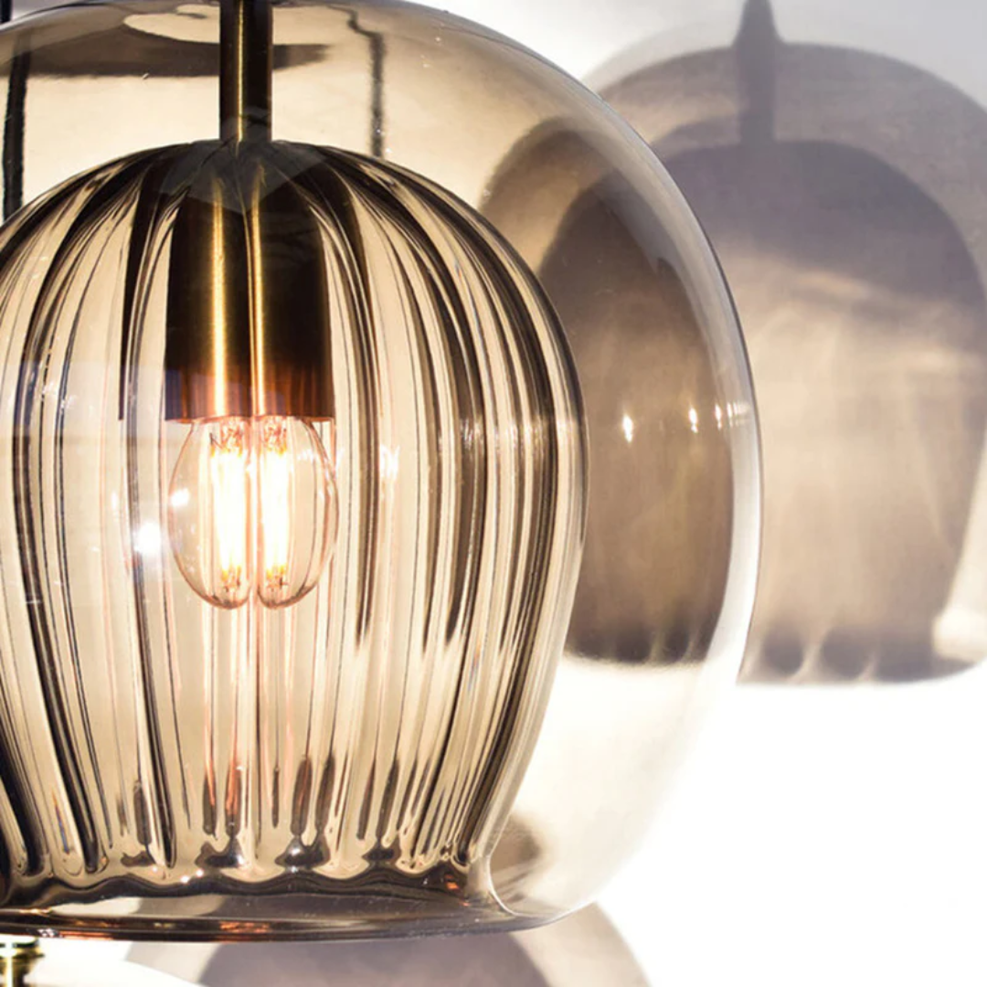 Amber glass spherical lampshade with ribbed inner fixture and glowing LED bulb