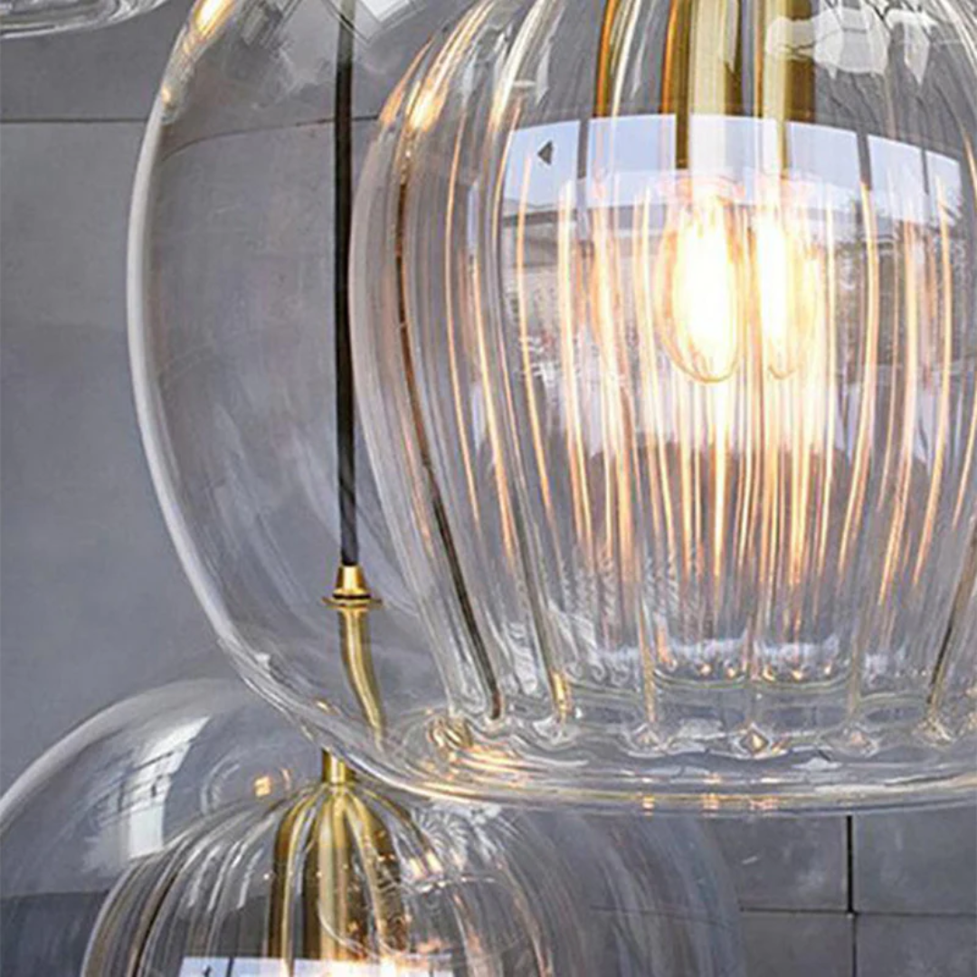 Modern spherical LED pendant light with amber glass shade lit up in a living room