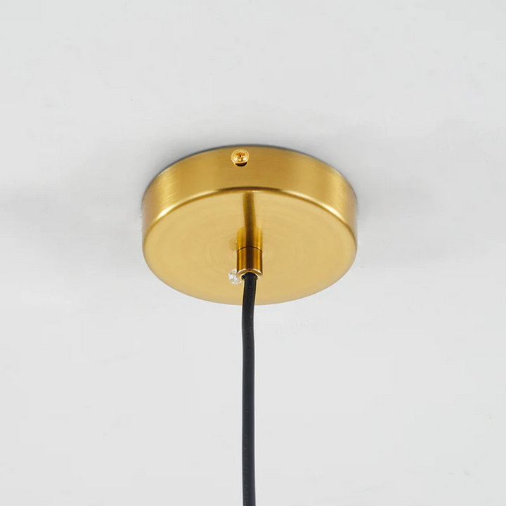 Gold metallic ceiling canopy and black suspension cord of the pendant light