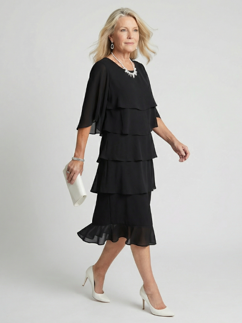 Side view of woman walking in the elegant black tiered midi dress