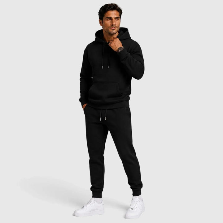 Man wearing black men's lounge set hoodie and joggers with white sneakers