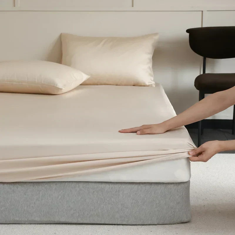 Latte brown luxury silk fitted sheet draped neatly on a modern home bed