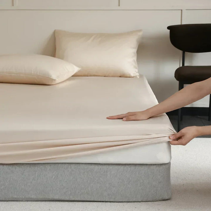 Latte brown luxury silk fitted sheet draped neatly on a modern home bed