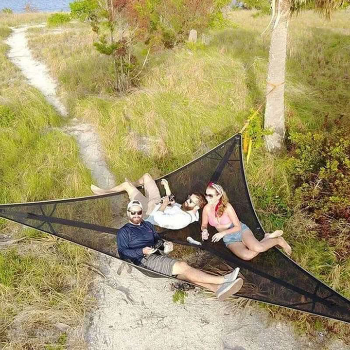Multi-person camping hammock suspended between trees with durable 3-point anchor system