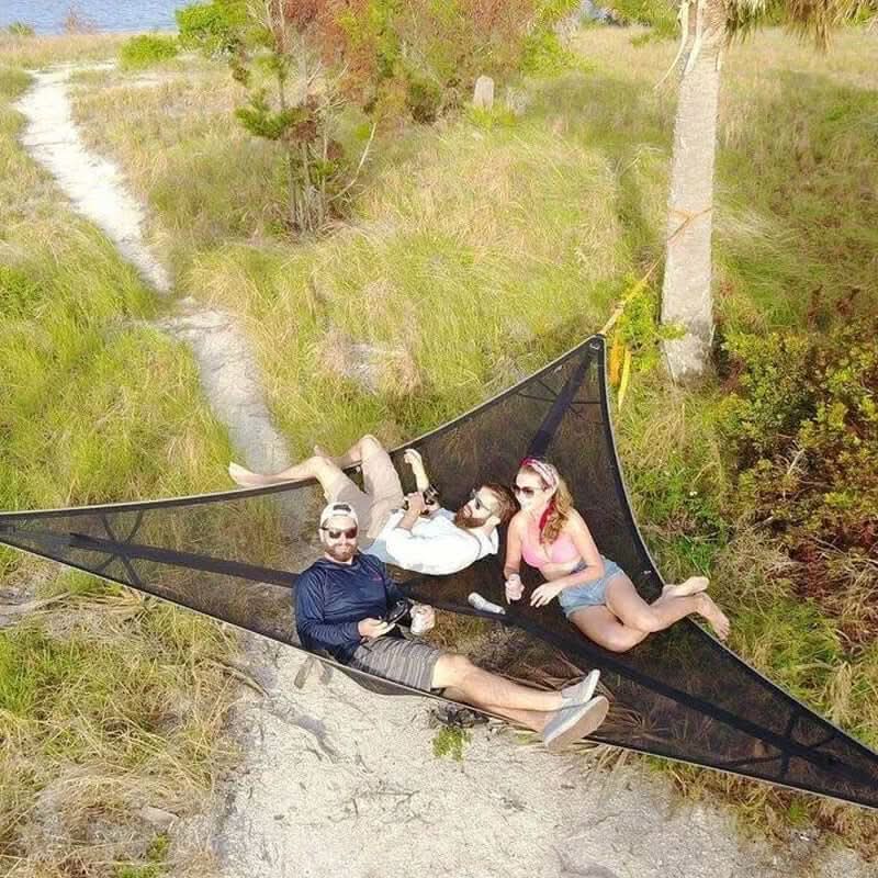 Portable triangle hammock set up for outdoor camping and relaxing in nature