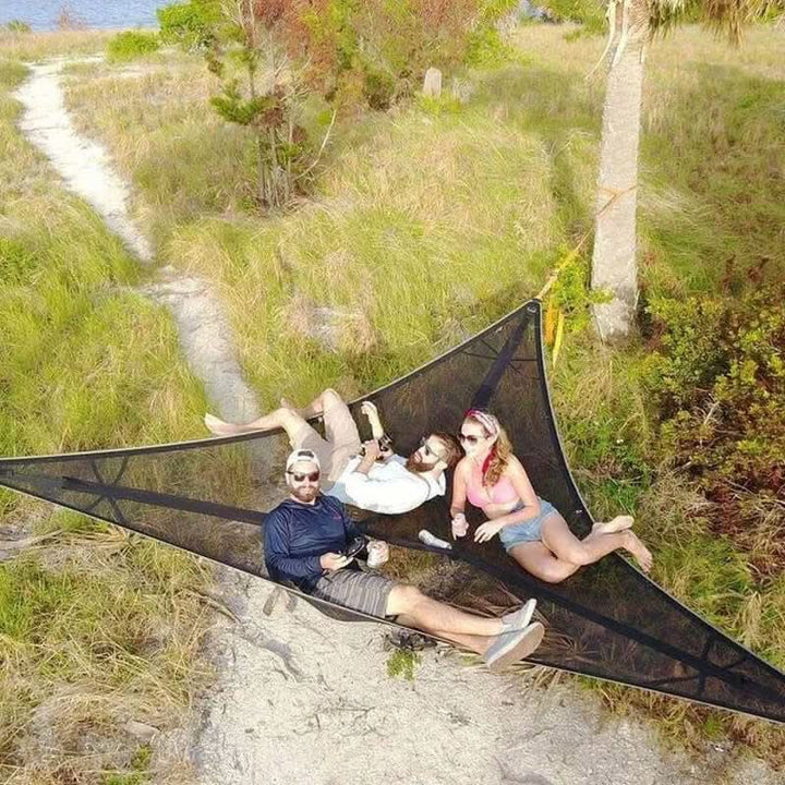 Portable triangle hammock set up for outdoor camping and relaxing in nature