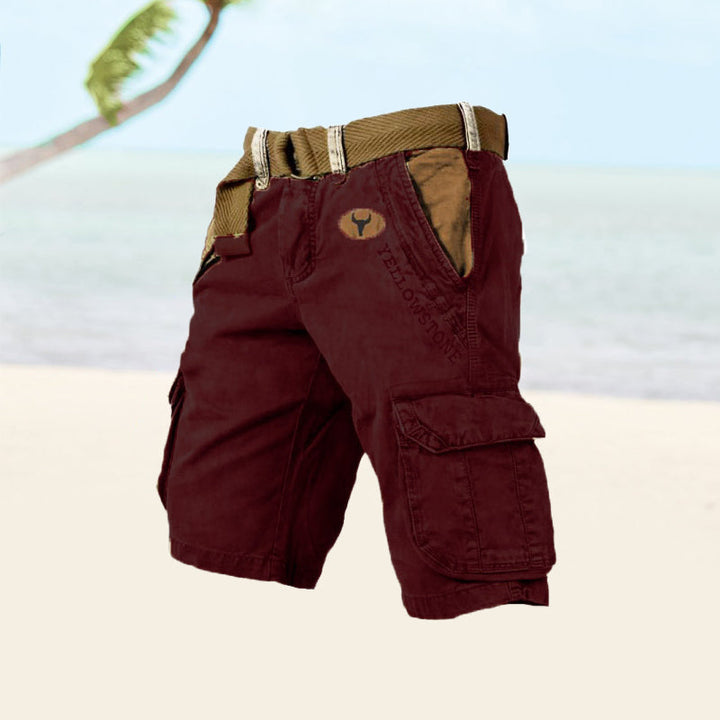 Men's red cargo shorts displayed against a beach backdrop