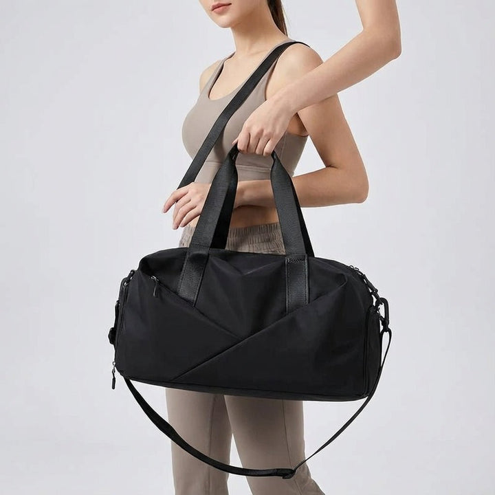 Woman holding a black multifunctional gym duffel bag over her shoulder