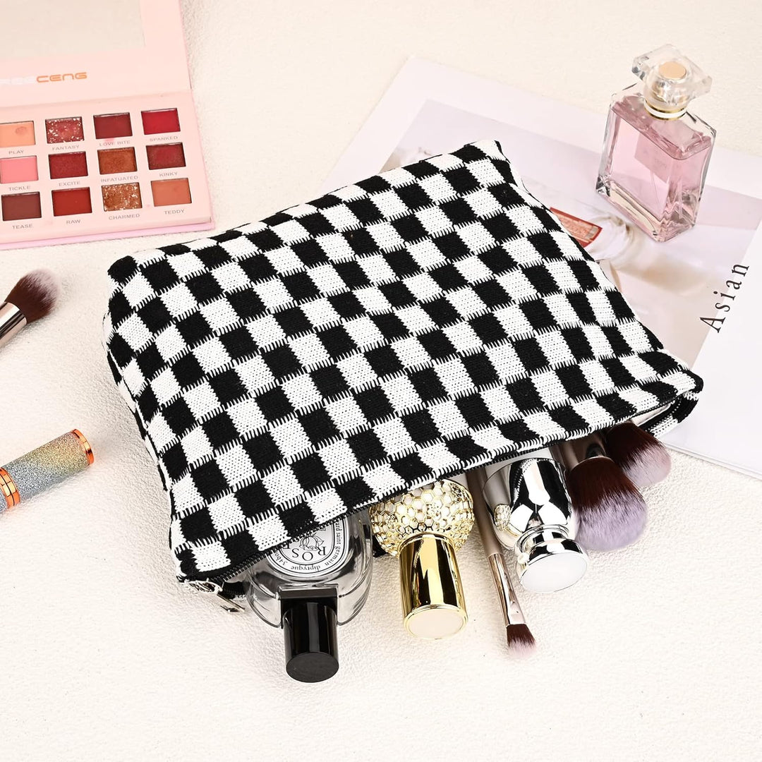 Checkered makeup bag filled with cosmetics and brushes on a display surface