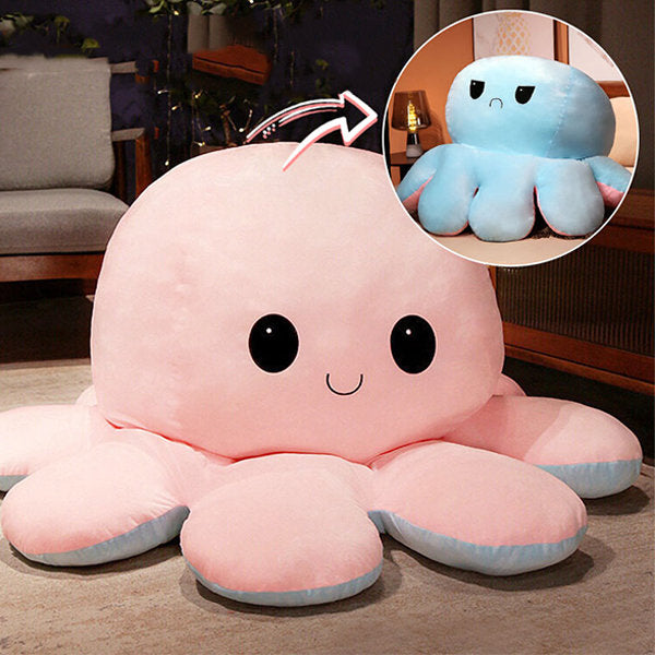 Large pink and blue reversible plush octopus toy in a room