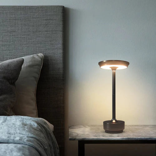 Portable ambient table lamp glowing softly in a dimly lit bedroom