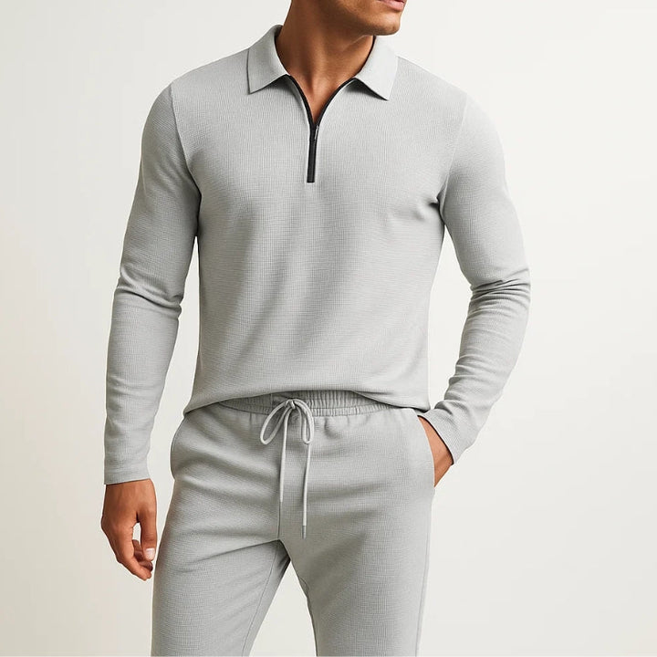 Man wearing a grey quarter zip polo tracksuit set