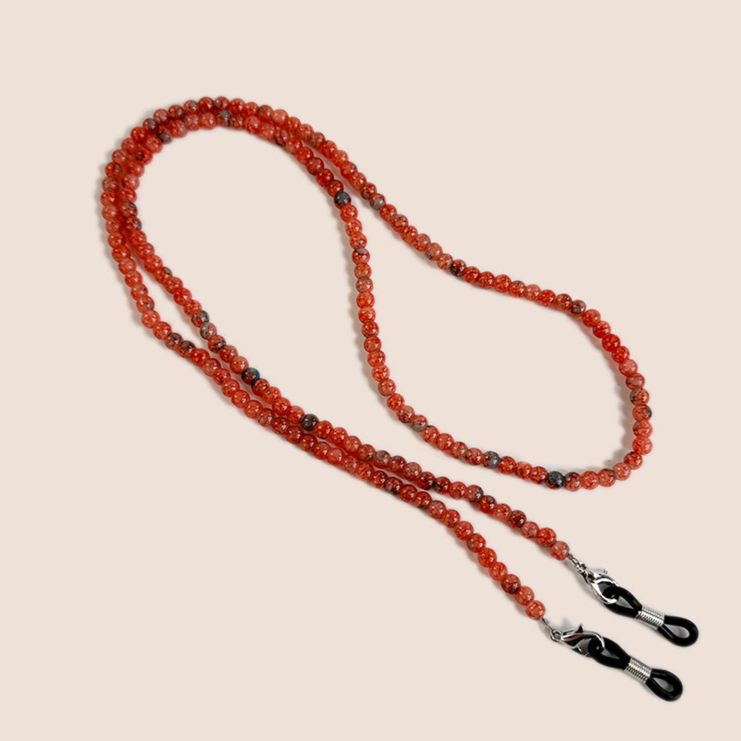 Red beaded glasses holder strap on neutral background