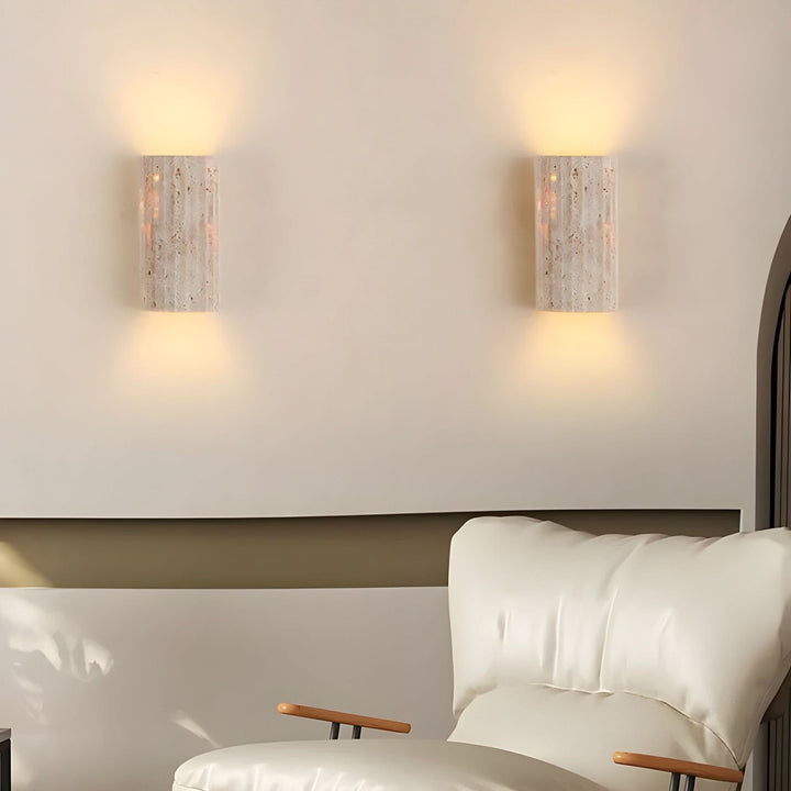 Natural stone LED wall sconce lights mounted on a neutral living room wall above a modern chair