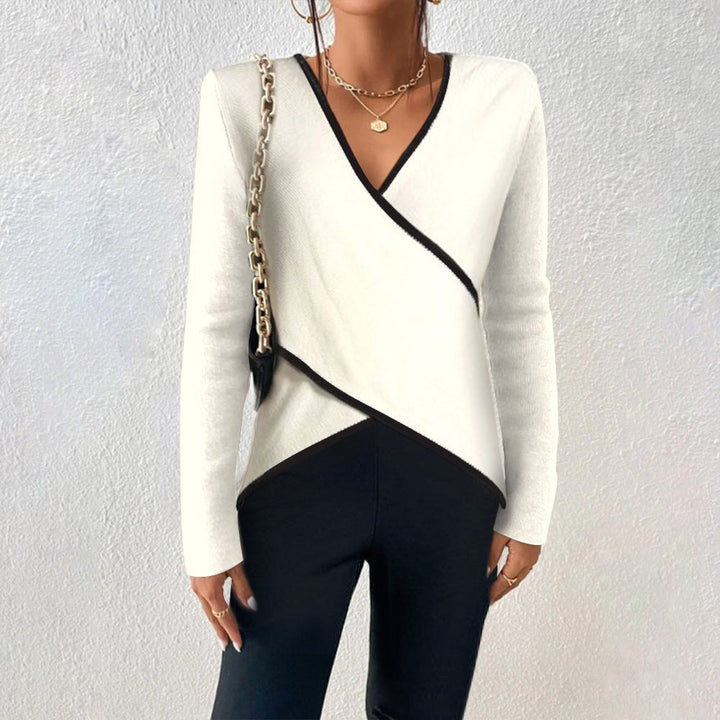 Women wearing a white V-neck pullover sweater with dark trousers
