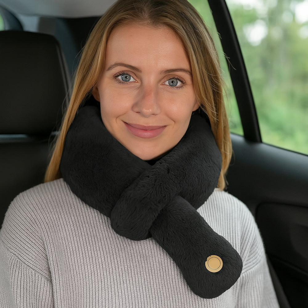 Woman smiling in a car wearing a black massage travel neck pillow
