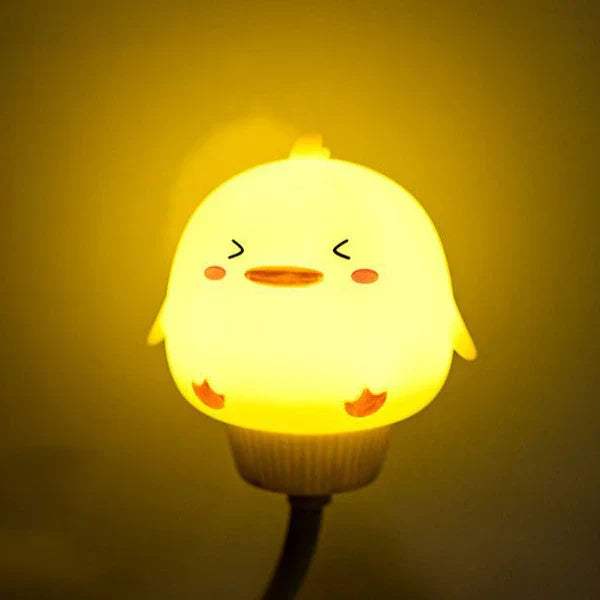 Bright yellow duckling USB night light glowing in a dark room