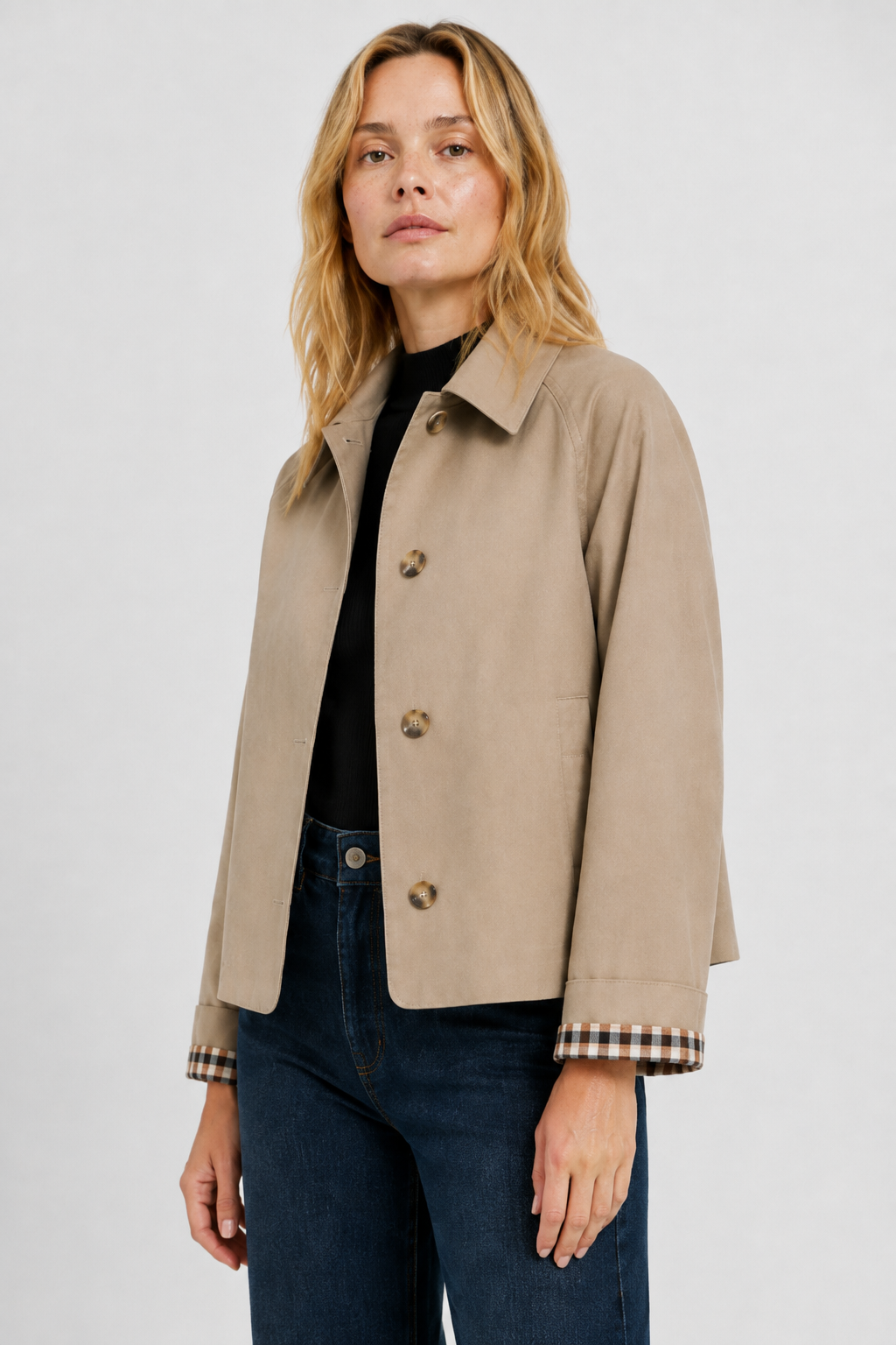 Close-up of a woman in a casual beige jacket with front button closure