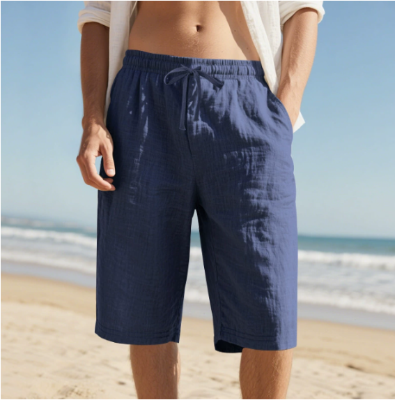 Man wearing navy blue drawstring knee length shorts on a beach