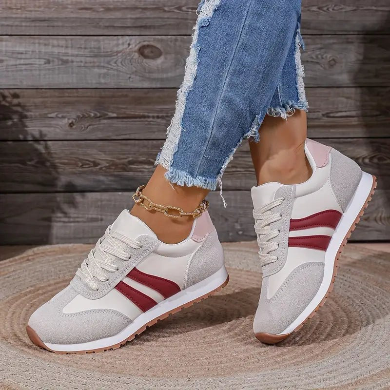 Women's casual trainers with red side stripe details worn outdoors