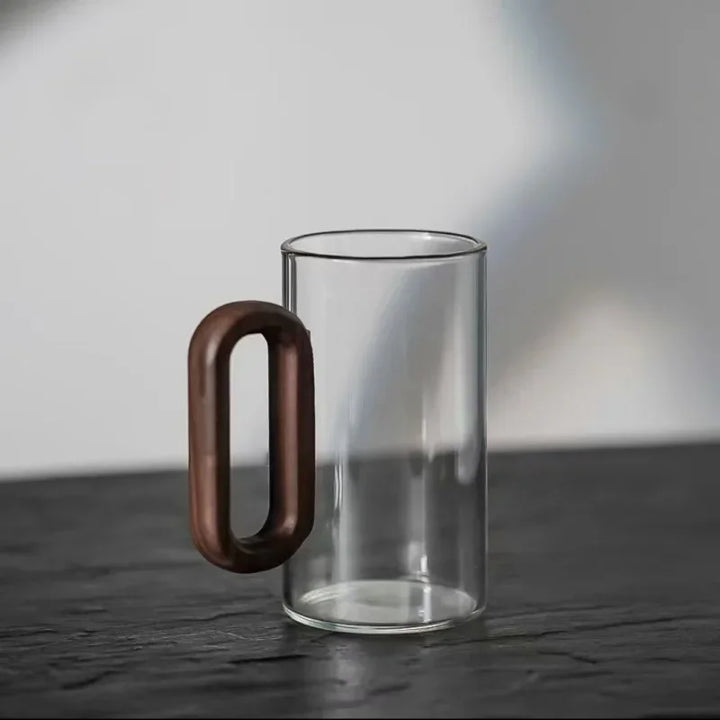 Clear glass mug with a wooden handle on a dark surface