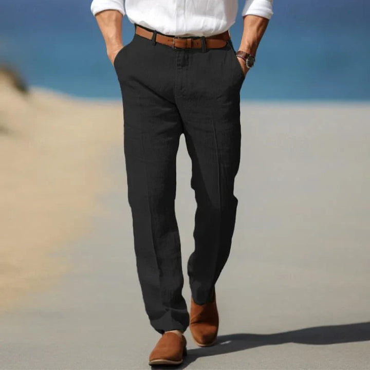 Man wearing black straight leg chino pants with a white shirt outdoors