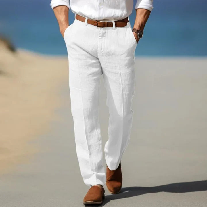 Man wearing white straight leg chino pants with a white shirt outdoors