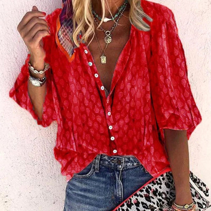 Woman wearing vibrant red button-front blouse with decorative buttons and accessories