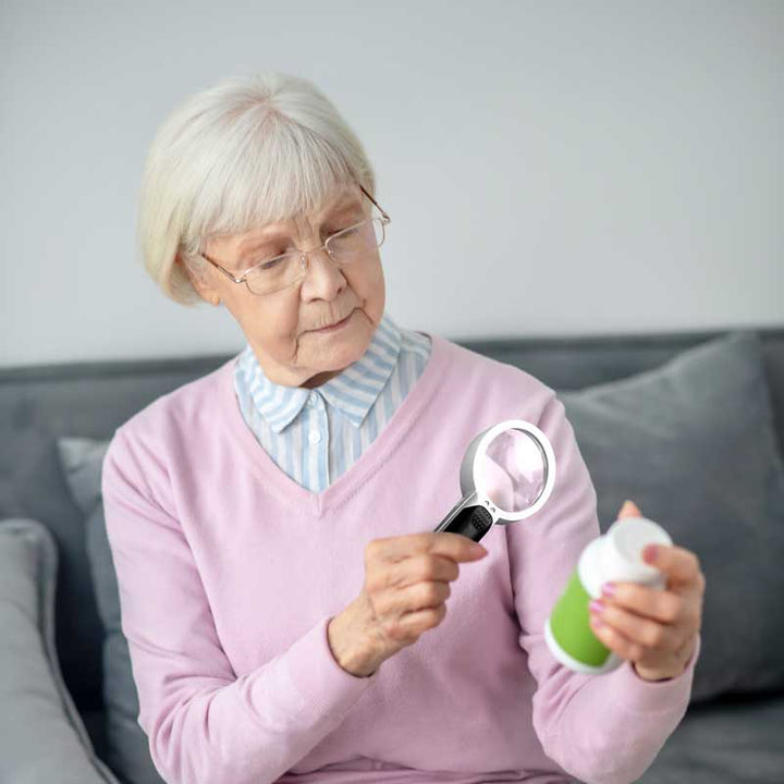 Low vision helper magnifying glass featuring an ergonomic handle and lights