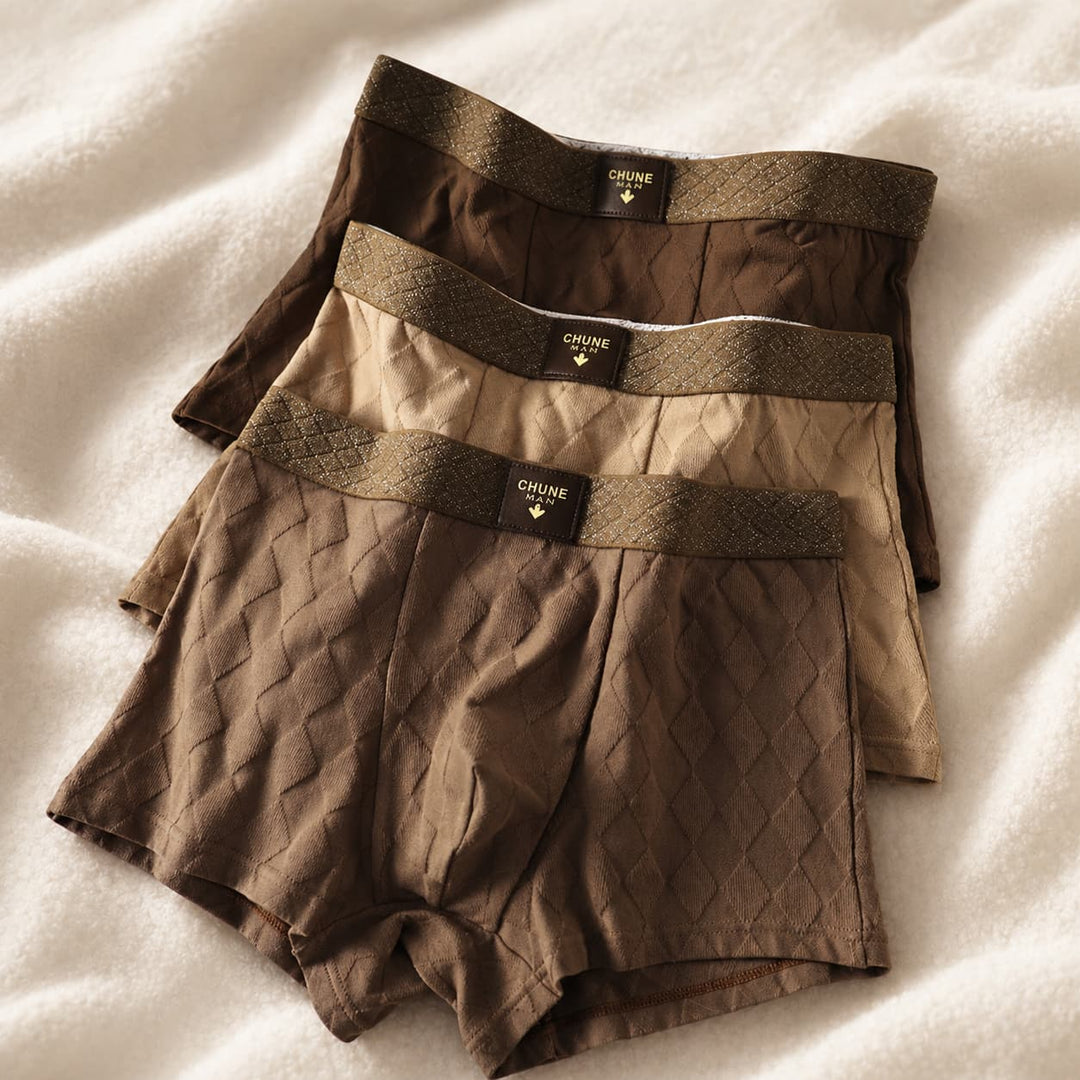 Folded men's boxer briefs in dark earth tones showcasing textured diamond weave