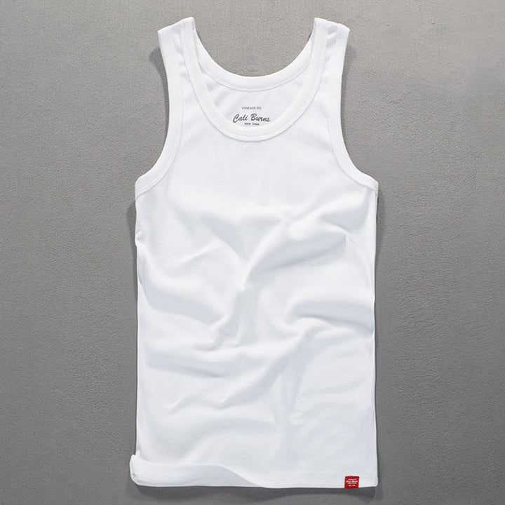 White men's tank top laid flat on a grey textured surface