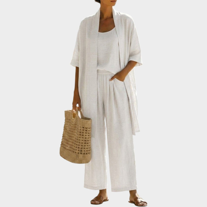 Woman wearing white casual three-piece outfit set with a woven bag