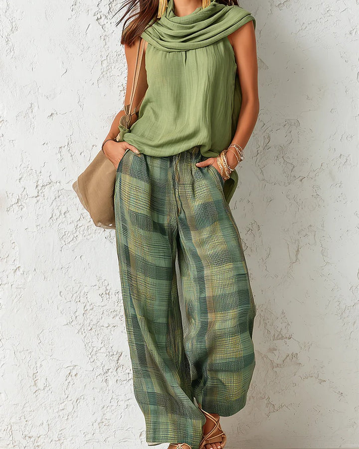 Front view of a woman wearing the green botanica two-piece outfit set with loose trousers and sleeveless top.