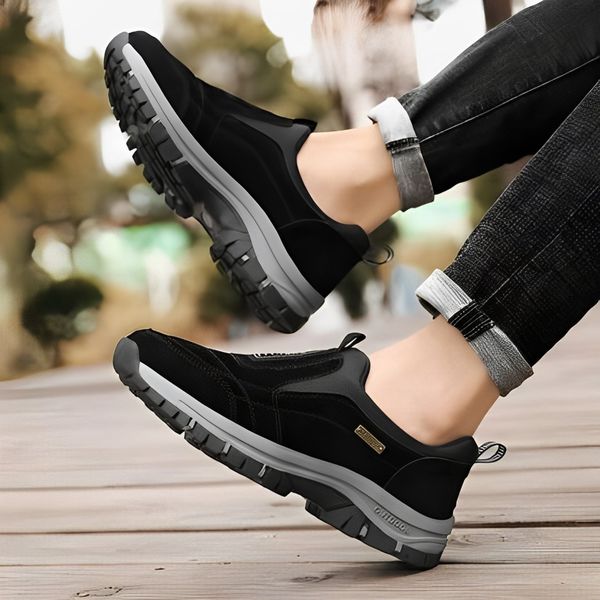 Side angle of black orthopaedic walking shoes being worn outdoors