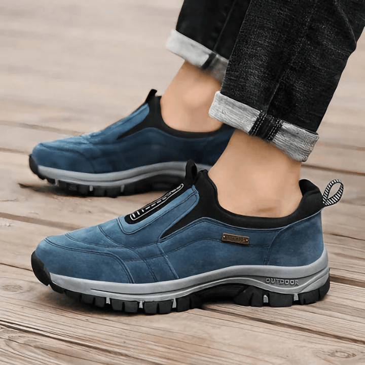 Close-up of blue orthopaedic walking shoes worn on wooden floor