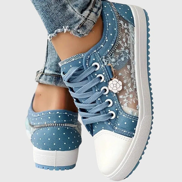 Side profile of women's blue comfort sneakers showing textured white outer soles