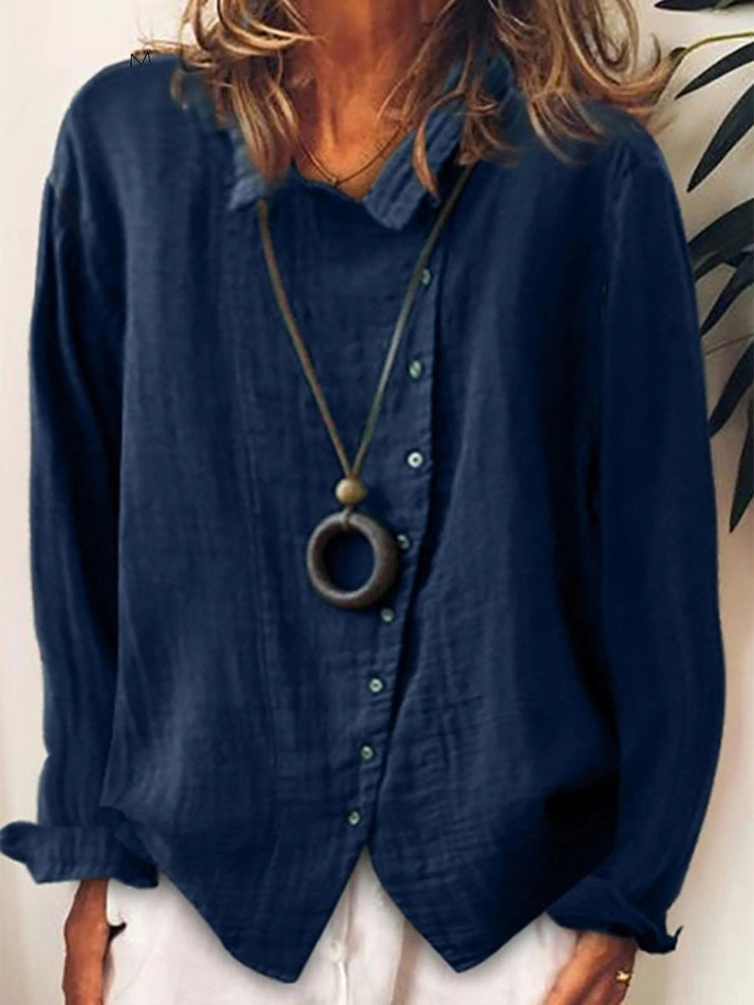 Woman wearing dark blue long sleeve boho blouse with button-up front
