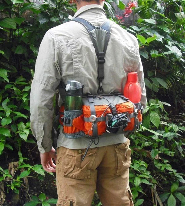 Hiker wearing the orange outdoor multi-pocket waist bag with water bottles attached on a trail