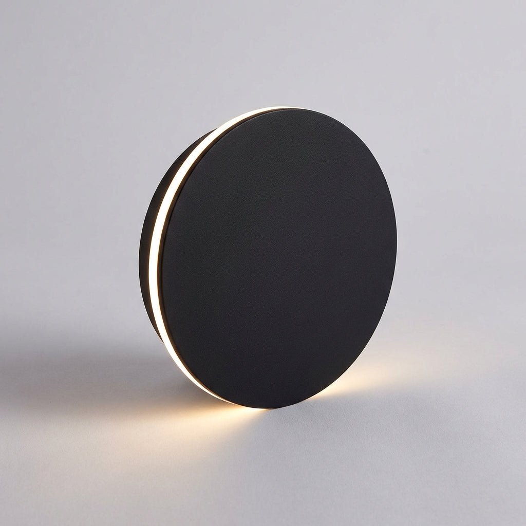 Modern black circular outdoor wall lamp casting up and down light on grey background