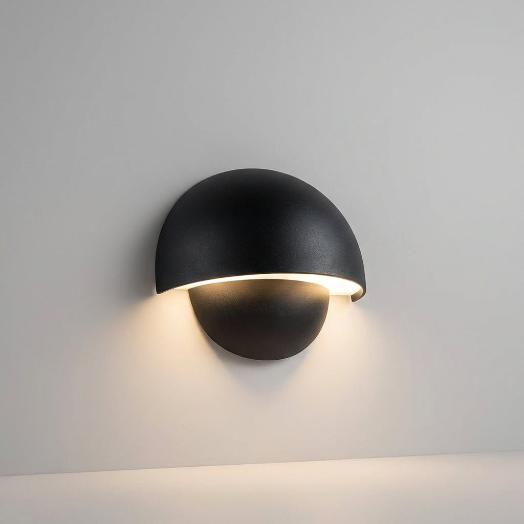 Modern black LED outdoor wall lamp mounted on a neutral wall, glowing softly.