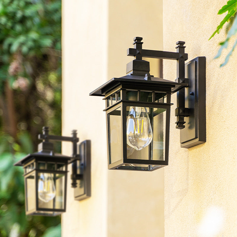 Black outdoor waterproof lantern wall light mounted on a stucco exterior wall