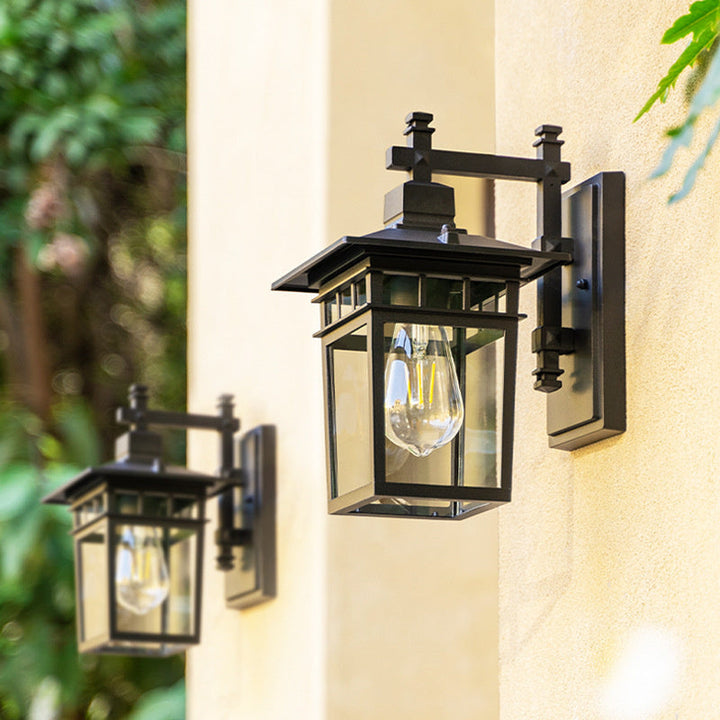 Black outdoor waterproof lantern wall light mounted on a stucco exterior wall